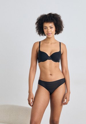 Sutien negru căptușit cu bretele ajustabile, textură netedă și cupe moi. Chiloți negri din material transparent, cu dungi orizontale subțiri.