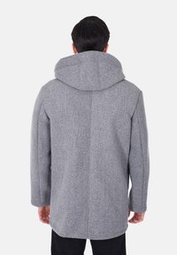 Cappotto di lana grigia con cappuccio ampio, maniche lunghe e taglio dritto. Presenta una texture liscia e un design minimalista.