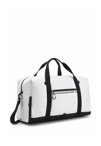 Sac duffle blanc avec poignées et base noires, poche avant zippée étiquetée BOSS et bandoulière amovible, posé sur fond blanc.