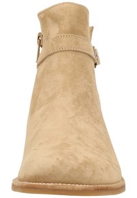 Beige Wildleder-Ankelboots mit glatter Textur, abgerundeter Zehenpartie, seitlichem Riemen mit Schnallendetail und flacher, brauner Gummisohle.
