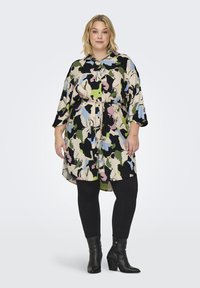 Χρωματιστό, μοτίβο φόρεμα πουκάμισο με ζώνη στη μέση, σε συνδυασμό μαύρου, πράσινου, ροζ και μπλε, συνδυασμένο με μαύρα κολάν και μπότες μέχρι τον αστράγαλο.