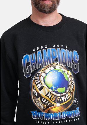 Black sweatshirt featuring a graphic print of a globe and championship ring, with "CHAMPIONS" text in bold blue and silver.