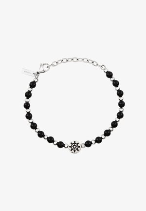 Silberarmband mit Kette, das abwechselnd schwarze Perlen und Metallakzente zeigt, mit einem dekorativen runden Anhänger in der Mitte.