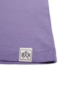 Purple cotton fabric with a smooth texture, featuring a small white label with the letters "B R" and crossed symbols at the hem.
