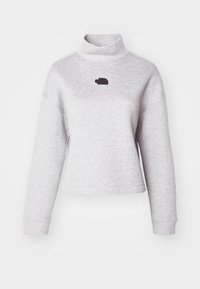 Maglione in cotone grigio a collo alto con maniche lunghe e vestibilità cropped. Presenta un piccolo logo nero sul petto. Texture morbida e design casual.