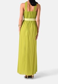 Maxi šaty v jasně limetkové barvě, vyrobené z lehkého materiálu. Mají nařasený korzet, široká ramínka a upravený pas.