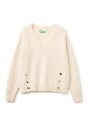 Jersey de manga larga con cuello de pico color crema, con puños, dobladillo y paneles laterales acanalados que cuentan con tres botones metálicos decorativos en cada lado.