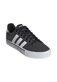 Baskets en toile noire avec des bandes blanches, bout rond, dessus texturé, semelle en caoutchouc plate et lacets noirs. Logo Adidas sur le talon.