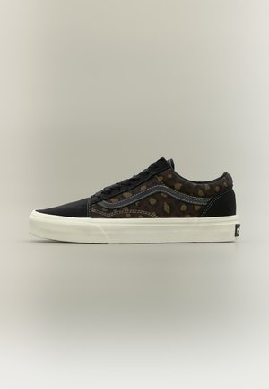 Lage schoen met zwarte neus en zijkanten met luipaardprint, witte zool, zwarte veters en opvallende zijkstrepen.