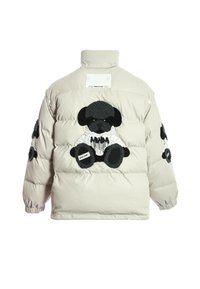 Chaqueta tipo puffer en color beige claro, con aplicaciones de diseños de osos en blanco y negro en la espalda y las mangas. Textura suave y acolchada con cuello alto.