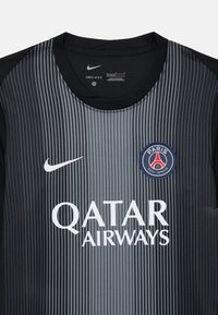 Crna i siva majica s vertikalnim prugama Nike Dri-FIT, koja ima okrugli ovratnik, logo Paris Saint-Germain i natpis "QATAR AIRWAYS".