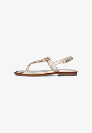 Sandalo piatto in oro metallizzato con design a T, decorato con gemme trasparenti e rosa, dotato di cinturino regolabile alla caviglia e suola marrone.