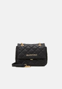 Sac à main en cuir noir matelassé avec quincaillerie dorée, doté d'un rabat avant, d'une chaîne et d'un logo "Valentino" en relief. Design structuré.