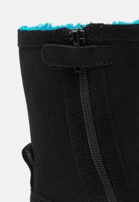 Czarny zamszowy but z turkusową futrzaną wyściółką, wyposażony w przedni zamek błyskawiczny i boczny zaczep dla łatwego zakładania, charakteryzujący się gładką fakturą i nowoczesnym designem.