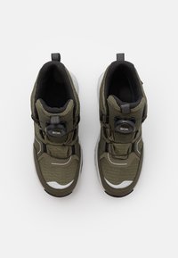 Wysokie buty sportowe w oliwkowym kolorze z teksturowanym materiałem, czarnymi akcentami i systemem sznurowania BOA. Posiadają białą podeszwę i detal logo.