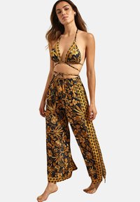 Haut de bikini à motif floral noir et or avec des liens et un pantalon ample assorti avec taille élastique et accent latéraux.