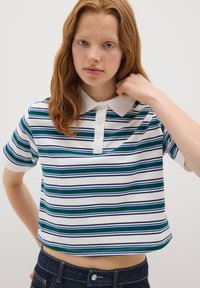 Polo shirt corto a maniche corte di colore bianco con righe orizzontali blu e verdi, dotato di colletto piatto e chiusura a tre bottoni.