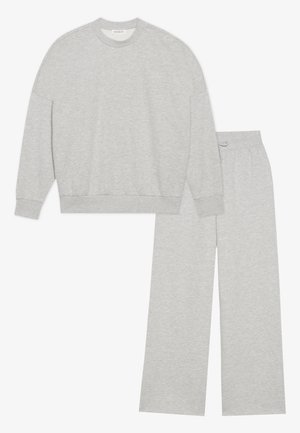 Šedý bavlněný teplákový set obsahující mikinu s kulatým výstřihem a žebrovanými manžetami, stejně jako široké kalhoty s elastickým pasem.