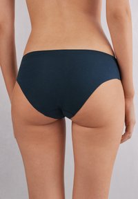 Granatowe bawełniane majtki bikini o gładkiej fakturze i niskim stanie, charakteryzujące się minimalistycznym designem oraz brakiem widocznych elementów hardware i wzorów.