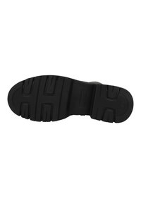 Suola di scarpa in gomma nera con scanalature profonde e superficie testurizzata. Presenta dettagli in rilievo e un logo rettangolare impresso sul lato.