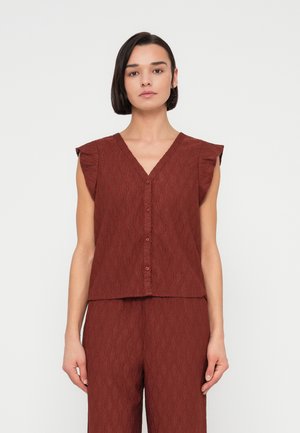 Μπορντό μπλούζα με κοντά μανίκια, υφασμάτινη με V-λαιμόκοψη και κουμπιά στο εμπρός μέρος. Διαθέτει διακριτικό κυματιστό σχέδιο και πιέτες στους ώμους.