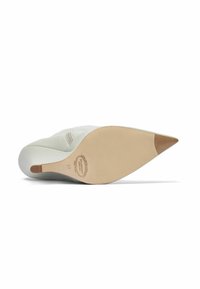 Zapato de tacón alto de punta afilada en cuero blanco liso con suela de goma beige. Presenta un logotipo en la plantilla y un tacón delgado para mayor elegancia.