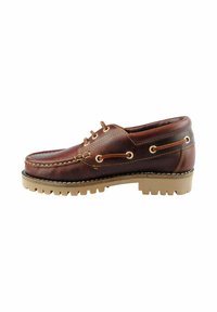Zapato de barco de cuero marrón con punta redonda, ojales dorados y costuras en contraste. Suela de goma gruesa con surcos profundos para un buen agarre.