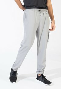 Light grey, lightweight joggers with an elastic waistband, drawstring, side pockets, and fitted cuffs. Made from smooth, breathable material.
