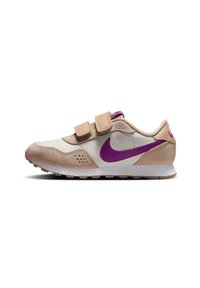 Zapatillas Nike con un diseño en beige y crema, materiales de ante y textil, correas de Velcro y un destacado logo swoosh en púrpura.