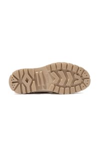 Semelle extérieure en caoutchouc beige avec une texture antidérapante, présentant de profondes rainures, des entailles et six trous de drainage. Marquée du logo "WALDHAUS".