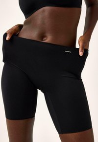 Højtaljede sorte cykelshorts lavet af strækbart materiale. Har en glat tekstur og et lille logo "Closely" på taljebåndet.