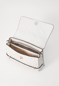 Borsa a tracolla bianca con modelli in rilievo, accessori dorati e chiusura a scatto. L'interno presenta più scomparti e una texture liscia.