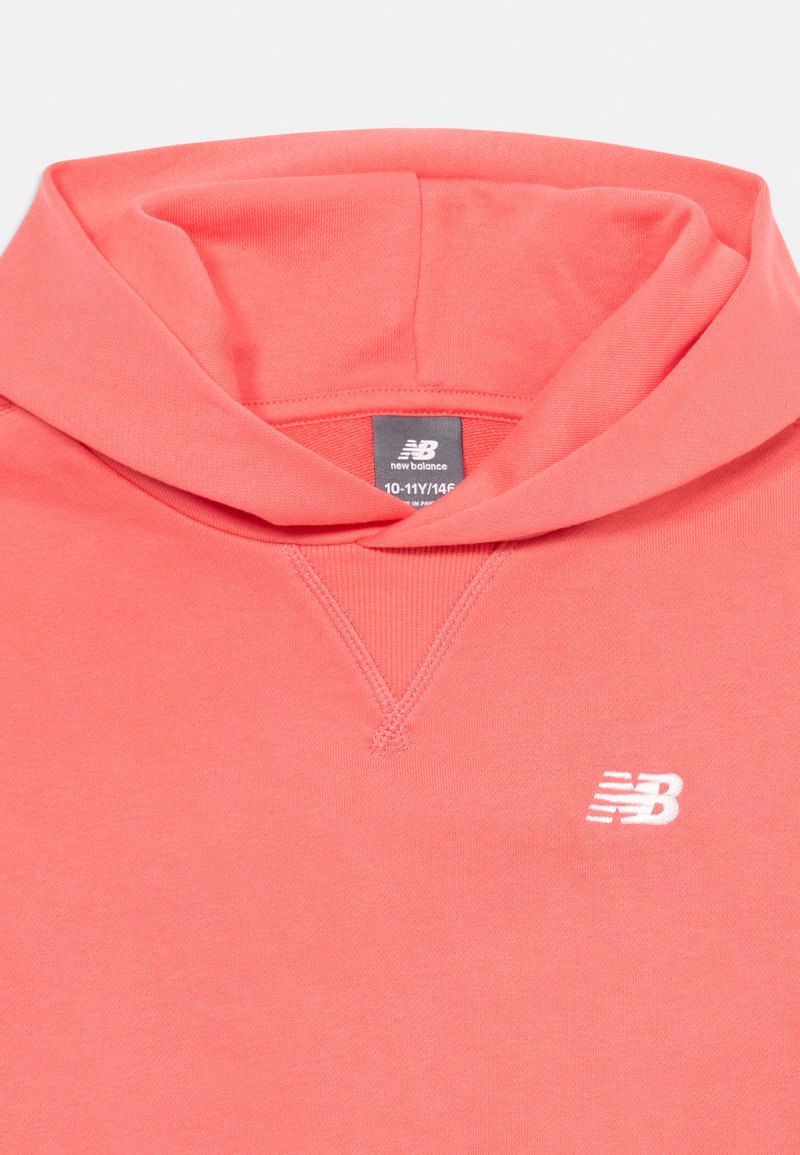 Hoodie rose corail en coton doux, avec une poche kangourou à l'avant, une capuche à cordon de serrage et un logo "N" blanc sur la poitrine.