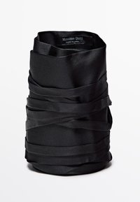 Black satin ribbon vase with twisted texture, featuring layered fabric for a sculptural effect. Label reads "Massimo Dutti, Made in China."
