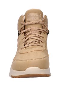Waterdichte beige sneaker met een getextureerde bovenkant, gewatteerde kraag, ronde veters en rubberen zool. Voorzien van branding op de tong en metallic accenten.