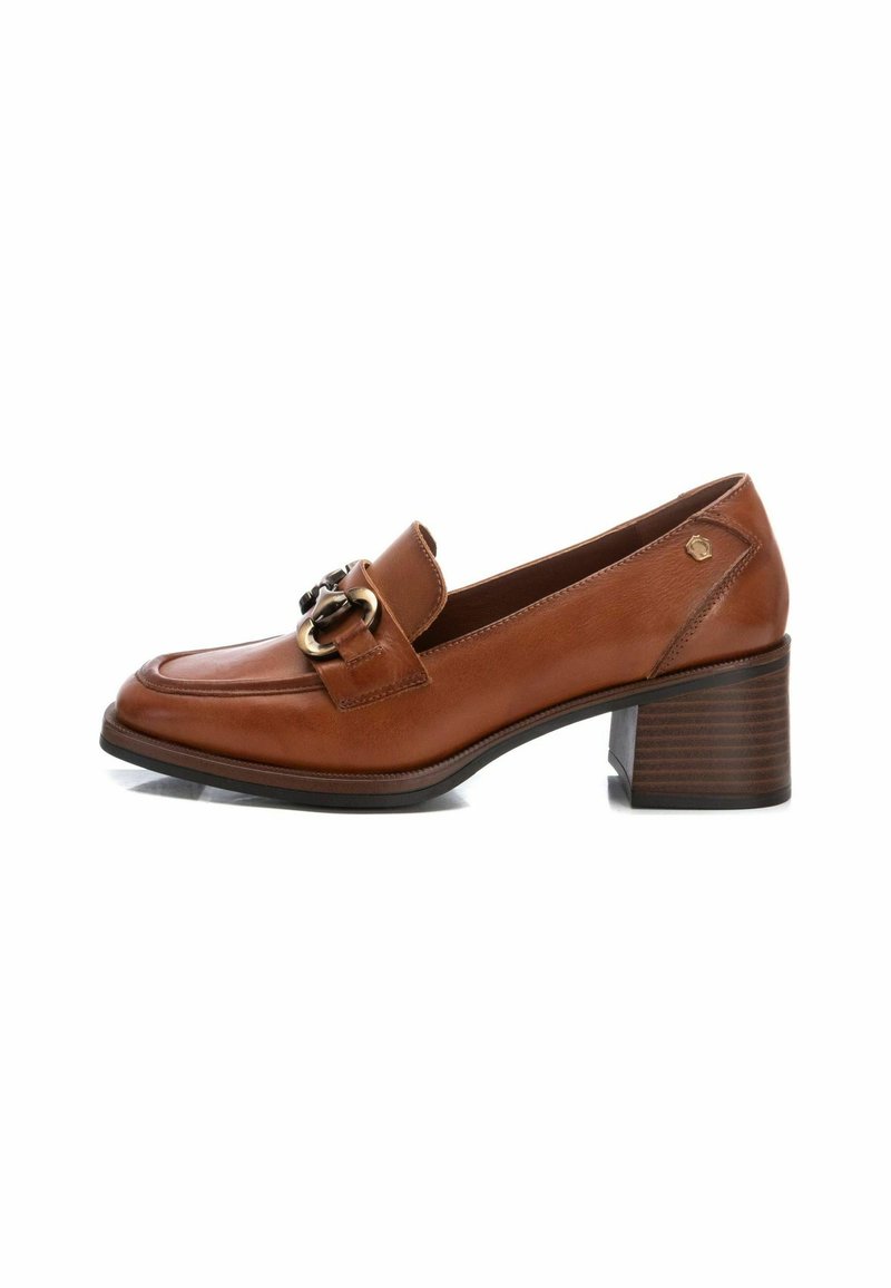 Mocasines de cuero marrón con puntera redondeada, una hebilla decorativa y un tacón de bloque apilado. Textura suave y detalles de costura sutiles.
