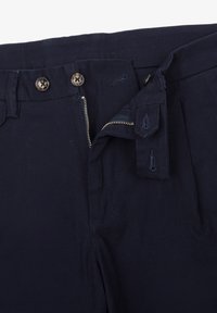 Pantaloni blu navy scuri con finitura testurizzata, dotati di due bottoni, zip e passanti per cintura. Cuciture visibili e aperture per tasche.