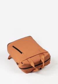 Zaino arancione con una finitura liscia e opaca. Presenta una cerniera superiore, spallacci regolabili e una tasca frontale con zip per ulteriore spazio di archiviazione.