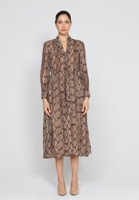 Maxi sukienka w wężowy wzór, z długimi rękawami, miękką teksturą i talią podkreśloną w pasie, w odcieniach brązu i kremu.