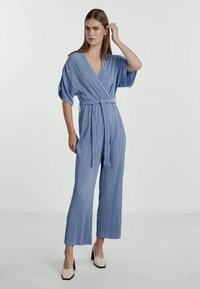 Blå plissert jumpsuit med omslagsdesign, korte ermer og knyttet midje. Den har brede, rette ben og en jevn tekstur, kombinert med hælsko.