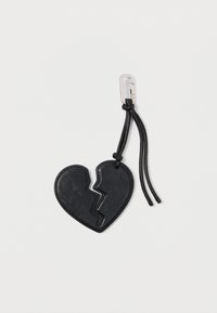 Portachiavi a forma di cuore in pelle nera con design di cuore spezzato, attaccato a un cordino nero con un gancio argentato. Texture liscia.