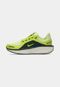 Nike hardloopschoen in felgeel en donkerblauw. Bevat een bovenwerk van текстurestof, veters, een gevoerde zool en GORE-TEX branding.