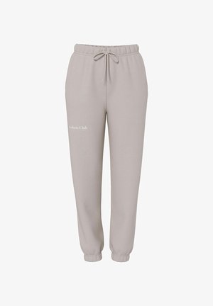 Pantaloni della tuta grigio chiaro con vita elasticizzata e coulisse regolabile. Presentano un logo stampato sulla gamba sinistra. Design morbido e casual.