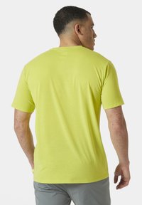 Camiseta ajustada de manga corta en un brillante verde lima, hecha de un tejido ligero con una textura suave, con un sutil logo cerca del cuello.