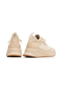 Sneakers beige chiaro con un mix di texture lisce e soffici. Presentano una punta tondeggiante, una suola spessa e lacci piatti per una vestibilità sicura.