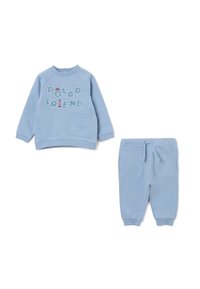 Sudadera de color azul claro con el texto "AMIGO POLAR" en letras texturizadas, combinada con pantalones de chándal a juego que cuentan con bolsillos laterales y cordón.