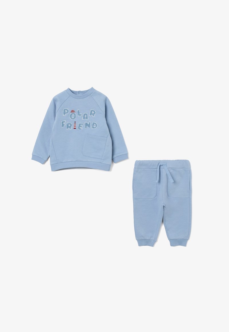 Sudadera de color azul claro con el texto "AMIGO POLAR" en letras texturizadas, combinada con pantalones de chándal a juego que cuentan con bolsillos laterales y cordón.