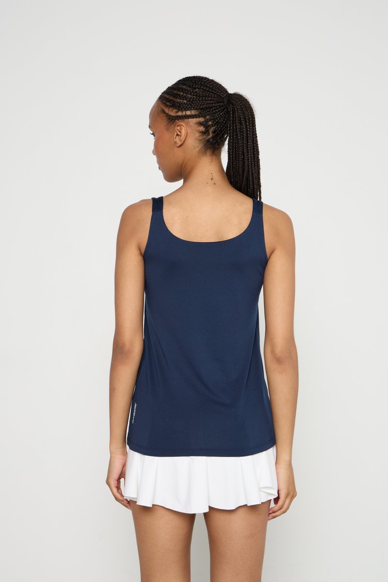Top sans manches bleu marine avec un décolleté arrondi, design ajusté et texture douce et lisse. Complété par une jupe plissée blanche.