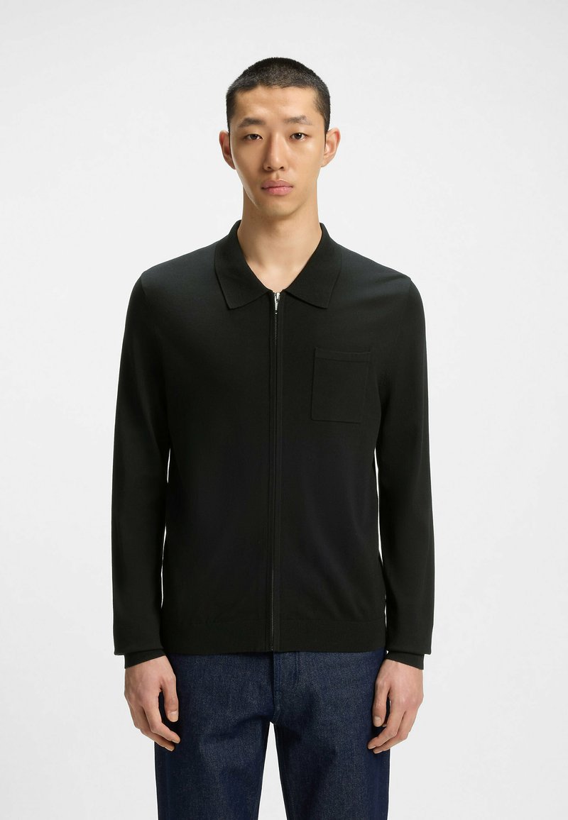 Cardigan nero con zip e colletto, dotato di tasca sul petto e maniche lunghe, realizzato in un tessuto liscio e texture.