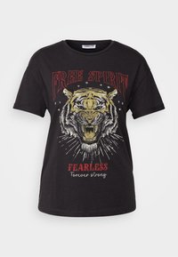 Melnas kokvilnas T-krekls ar tīģera grafiku, tekstu "BEZMAKSAS GARĪBA" sarkanā krāsā un "DROSMAIS uz visiem laikiem stiprs" baltā krāsā zem attēla. Īsas piedurknes.